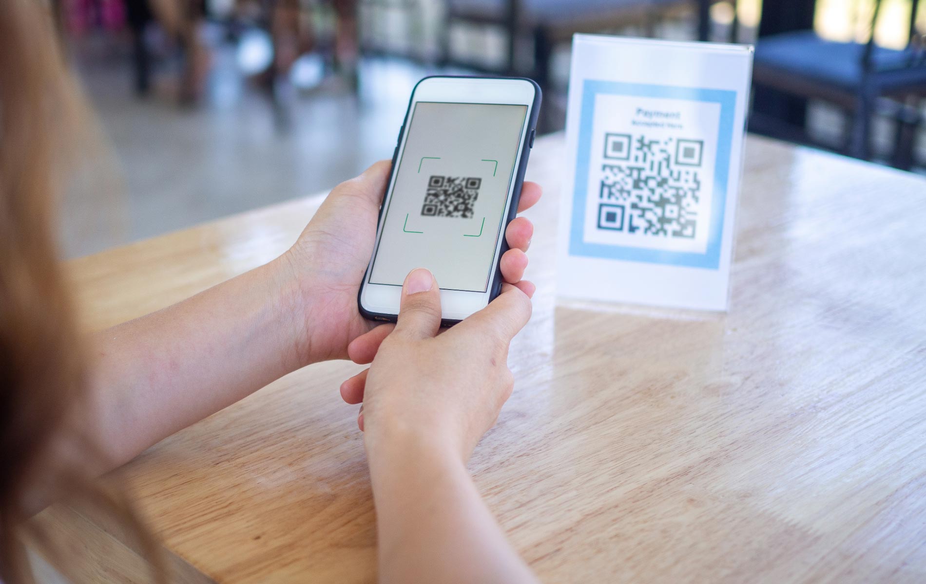 An event attendee scanning a QR code at a vendor's booth.